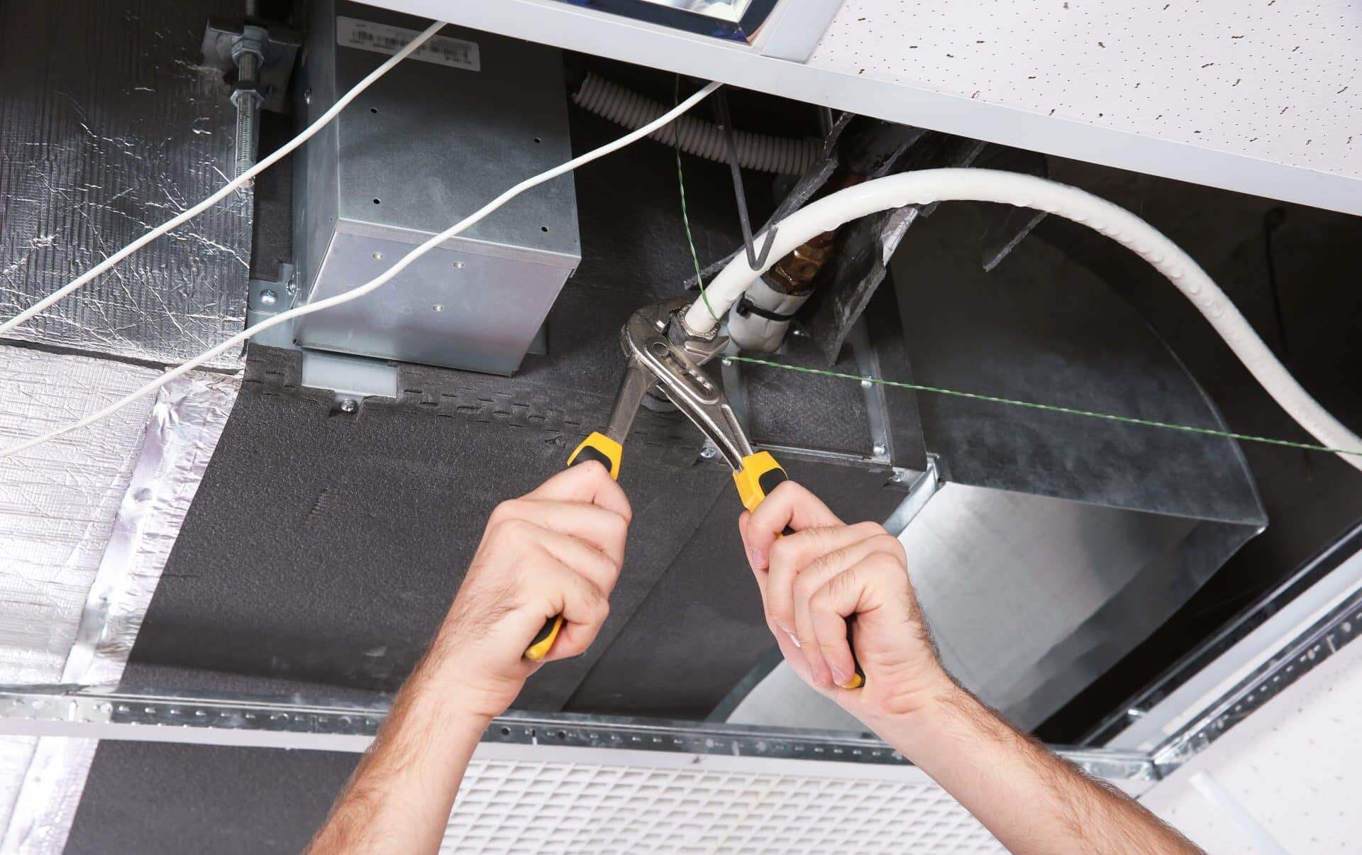 Technician repairing ducted air conditioning system