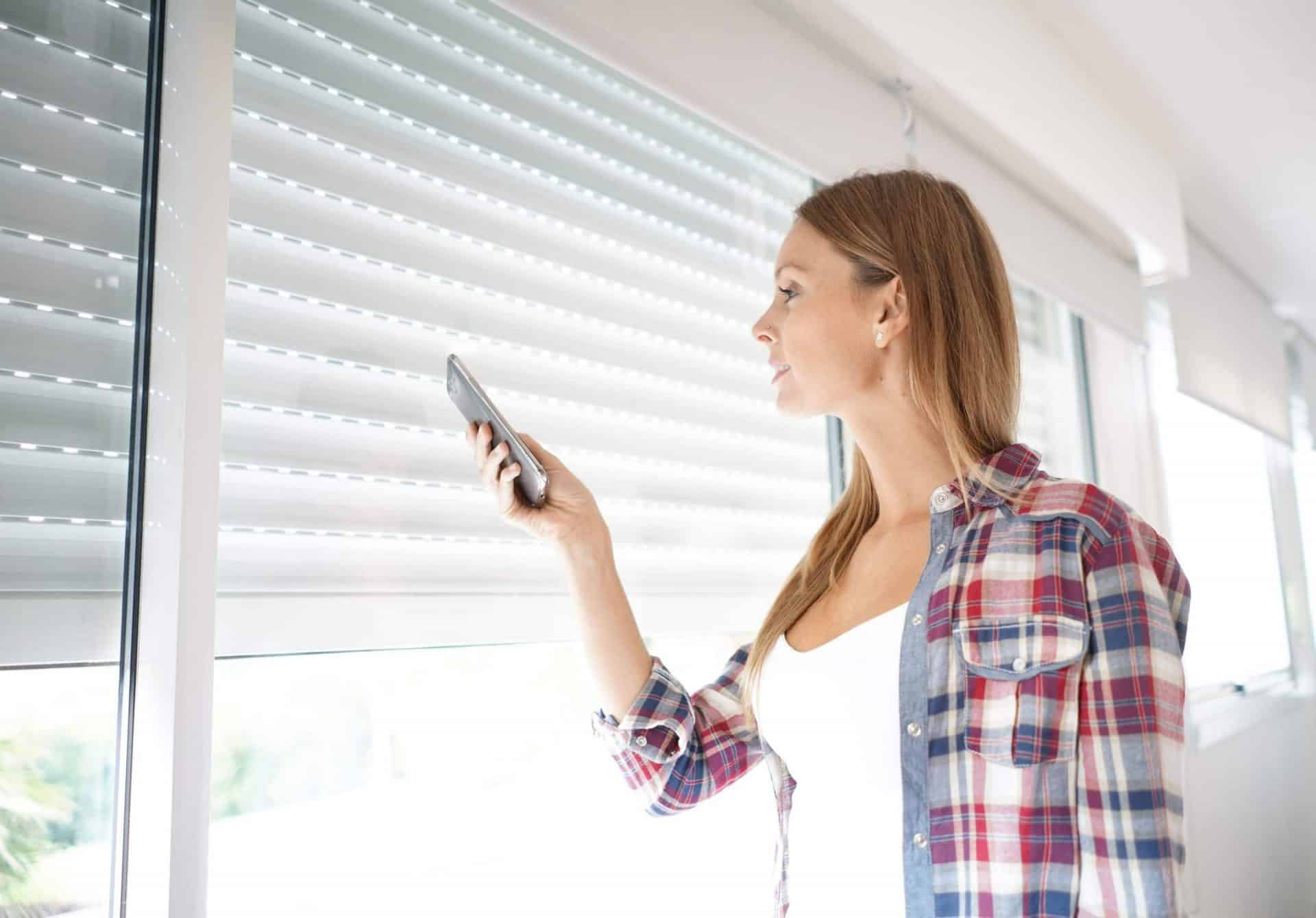 Woman using MyPlace smart system with blinds