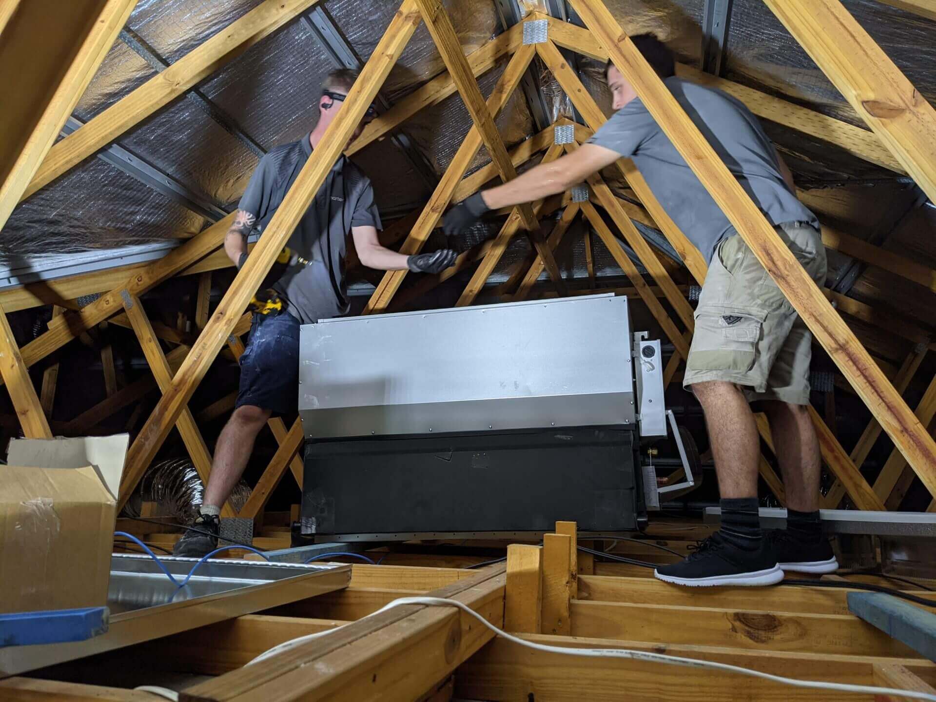 Two men working in attic space