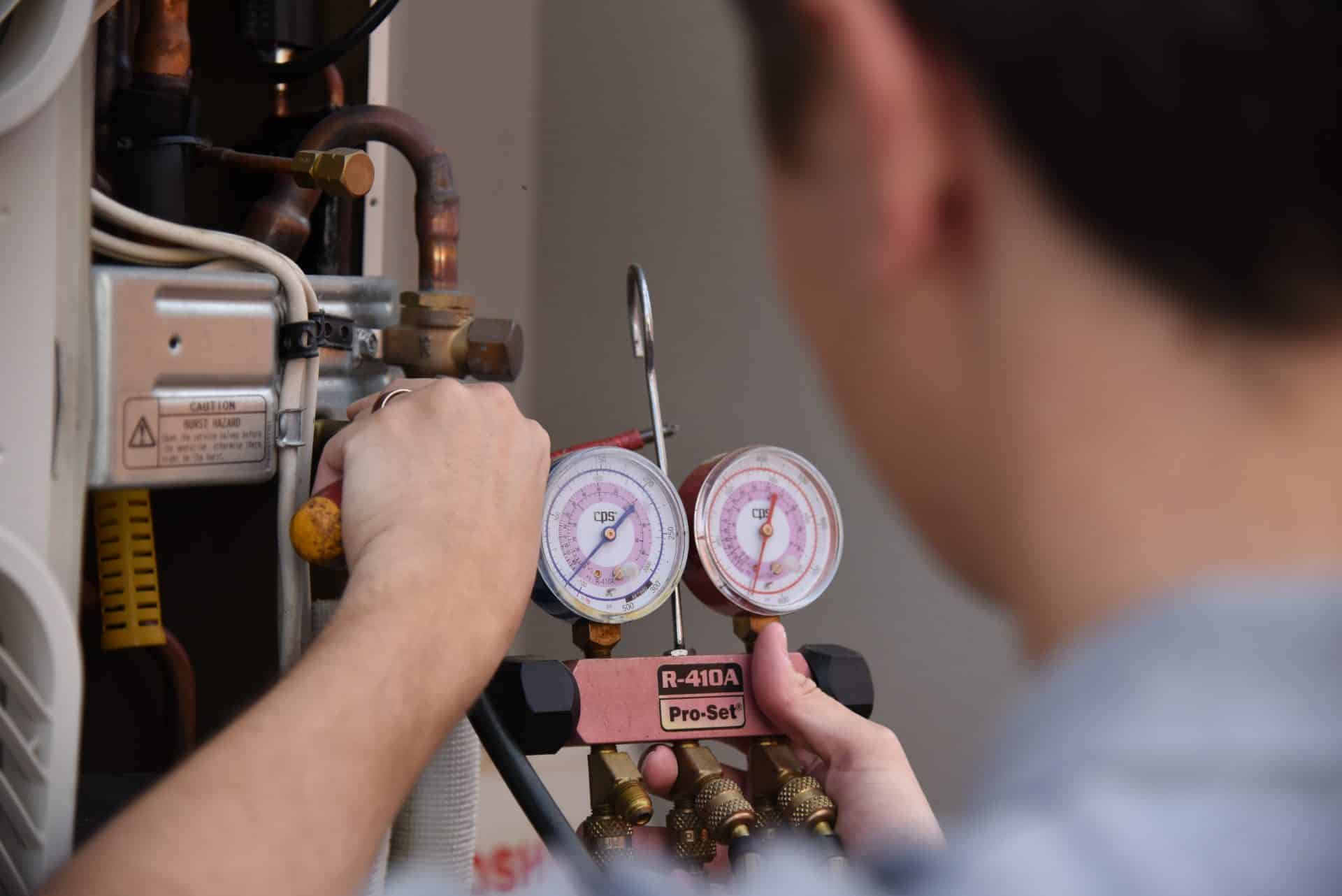 air-conditioning-repair-gauges man reparing air conditioning gauge